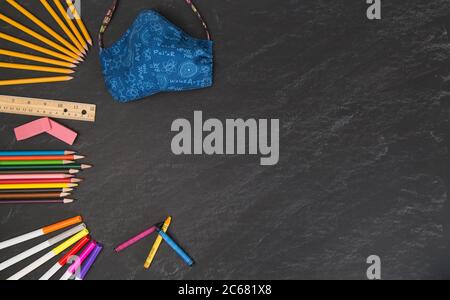 Science Thema Gesichtsmaske mit zurück zur Schule liefert auf einer grauen Tafel Stockfoto