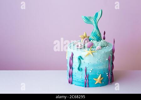 Mermaid Geburtstagskuchen auf einem lila Hintergrund Stockfoto