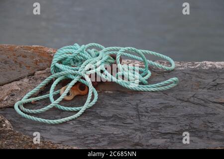Seil liegt am Dock mit Wasser im Hintergrund Stockfoto
