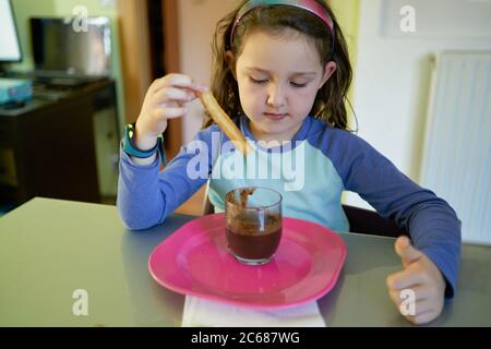 Kleines Mädchen essen Schokolade Dessert mit Fritten Stockfoto