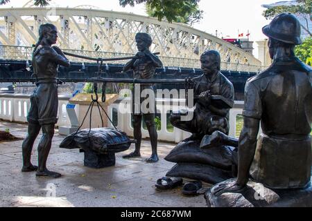 Der Bronzeskulpteur 'EIN großes Emporium' in Raffles Place am Singapore River. Eines von vier Stücken, die Teil der Menschen der River Skulptur sind. Stockfoto