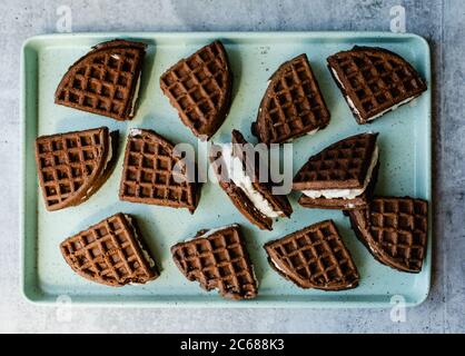 Hausgemachte Eis-Sandwiches auf einer minzgrünen Blechpfanne. Stockfoto