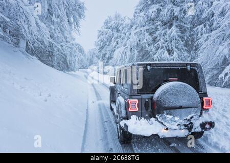 4x4 in verschneiten Straße in einem Wald Stockfoto