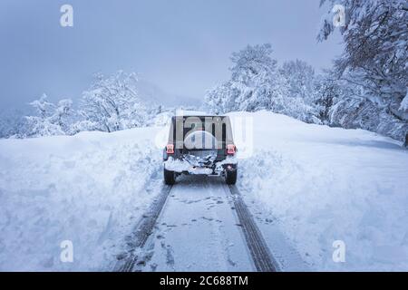 4x4 in verschneiten Straße in einem Wald Stockfoto