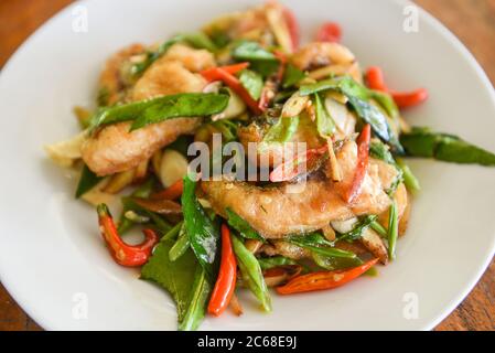 Thai Food gebratener Fisch mit Pfeffer Chili und Kraut auf weißem Teller / Tilapia Fisch gekochte Speisen Stockfoto