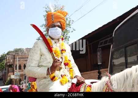 Jodhpur, Rajashtbn, Indien. 30. Juni 2020: Indischer Bräutigam trägt Maske auf Pferd sitzend, Menschen heiraten nach Leichtigkeit in Sperre während COVID-19 pa Stockfoto