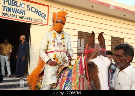 Jodhpur, Rajashtbn, Indien. 30. Juni 2020: Indischer Bräutigam trägt Maske auf Pferd sitzend, Menschen heiraten nach Leichtigkeit in Sperre während COVID-19 pa Stockfoto