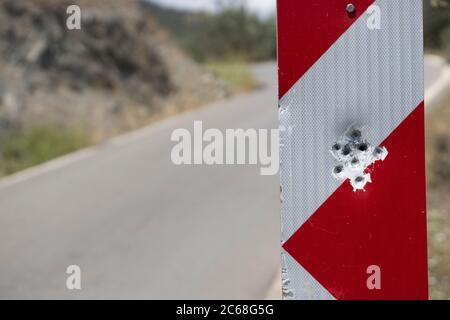 Rotes Straßenverkehrsschild voller Einschusslöcher. Nahaufnahme. Stockfoto