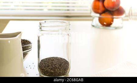 Chia Samen schließen sich in einer Glasschale auf weißem Hintergrund. Chia Samen Pudding mit frischen Früchten Rezept. Stockfoto