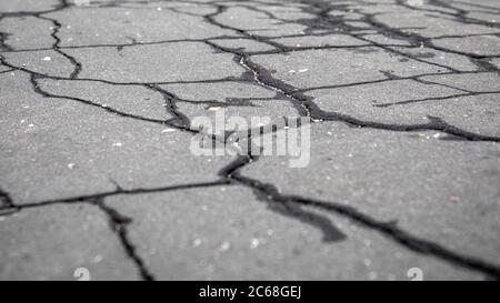 Rissige, nasse Asphaltdecke. Verkehr, Straßenreparaturen, Wetter und schlechte Qualität Konzept. Städtische Umwelt. Horizontales Banner Stockfoto