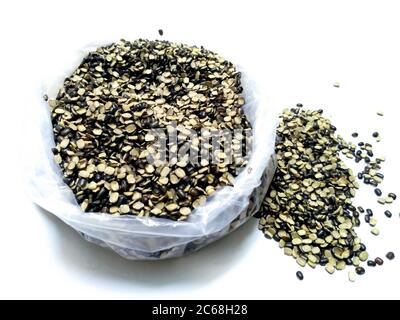 Split Black Lentil auch bekannt als Black Gram, Black Urad Dal, Vigna Mungo, Urad Bean, Urad Dal, Minapa Pappu, Mungo Bean oder Black Matpe Bean isoliert auf Stockfoto