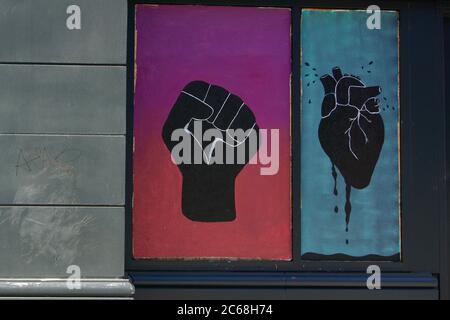 Black Lives Matter Street Art einer bemalten schwarzen Faust und tropfendem schwarzen Herzen auf den Fenstern in Downtown Oakland nach den Protesten von George Floyd. Stockfoto