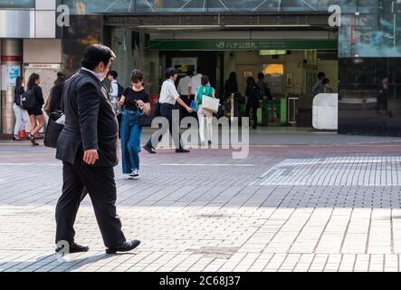 Büroangestellter in Geschäftsanzug mit Aktentasche am Shibuya Hachiko Square, Tokio, Japan. Stockfoto