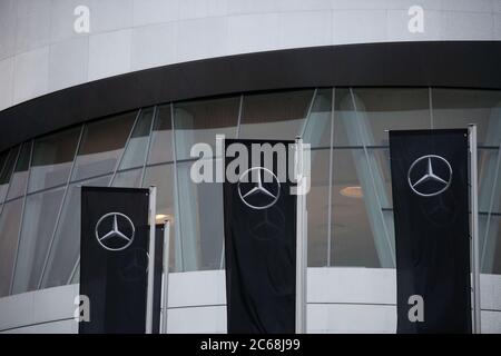 Stuttgart, Deutschland. Juli 2020. Mercedes Benz Flaggen fliegen vor dem Mercedes Benz Museum. Aufgrund der Corona-Pandemie wird die Hauptversammlung des Automobilherstellers Daimler später als geplant und nur online stattfinden. Daimler-Chef Källenius will das Unternehmen straffen und effizienter machen. Tausende von Arbeitsplätzen sollen abgebaut, Kosten gesenkt und Prioritäten neu organisiert werden. Die Gewinne des Unternehmens waren bereits vor der Corona-Pandemie im Jahr 2019 zusammengebrochen. Quelle: Marijan Murat/dpa/Alamy Live News Stockfoto