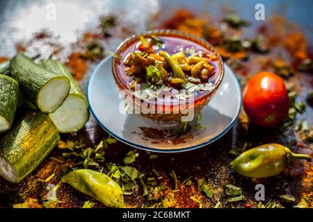 Nahaufnahme von frischem indischem Mittagsgericht Luffa oder Galka nu Shaak in einem Glasbehälter mit allen Zutaten auf einer rostfarbenen Oberfläche. Stockfoto