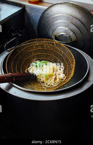 Gebrühtes gelbes Ei, das auf einem Sieb ruht Stockfoto