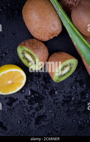 Nahaufnahme von essbaren Früchten und Blättern in gelb und grün. Kiwi, Zitrone und Aloe Vera. Stockfoto