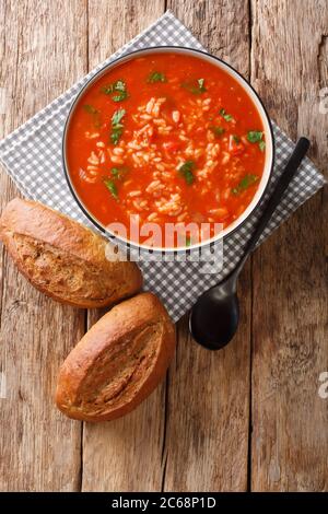 Hausgemachte vegetarische Tomatenreissuppe aus nächster Nähe in einer Schüssel auf dem Tisch. Vertikale Ansicht von oben Stockfoto