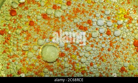 Öl bläht in Wasser. Gelbe und rote Farben und Orange. Stockfoto