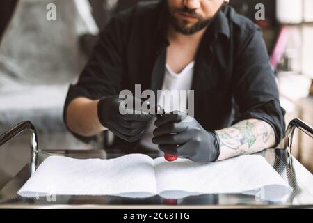 Close up professionelle Tätowierer in schwarzen Handschuhen Vorbereitung Ausrüstung für die Arbeit im Studio Stockfoto