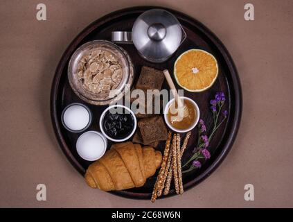 Ein perfekter Frühstückstisch aus frischem Obst: Und Orange, verschiedene Brotsorten: Croissants, Sesambrot und geröstetes Brot, Marmelade, salzige Sticks, Eier Stockfoto