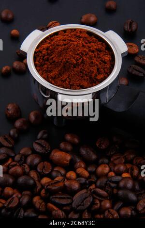 Kaffeebohnen und Kaffeepulver im Behälter und draußen zusammen. Stockfoto