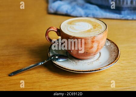 Kaffee mit Milch in einer Tasse. Cappuccino. Auf hellbraunem Hintergrund. Café Stockfoto