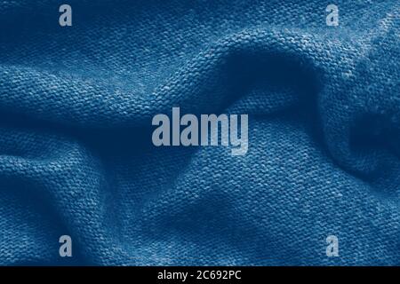 Gestrickter Texturhintergrund in Trendblau für Tapeten und Hintergründe. Hausgemachte Strickwaren. Stockfoto