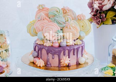 Festliche schöne Torte mit bunten Bagues und violetter Glasur. Rosa, gelb, lila, grün. Stockfoto