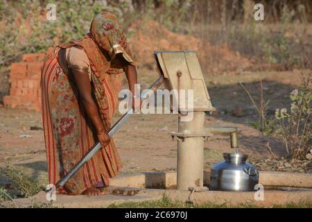 TIKAMGARH, MADHYA PRADESH, INDIEN - 24. MÄRZ 2020: Unbekannte Inderin, die Handpumpe für Trinkwasser verwendet. Stockfoto