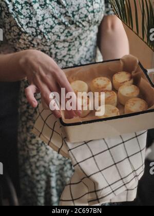 Frau hält ein Gericht mit Käsekuchen Stockfoto