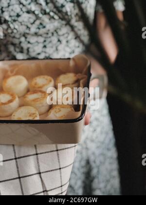 Frau hält ein Gericht mit Käsekuchen Stockfoto