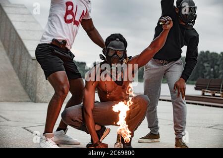 Junge aggressive afrikanamerikanische Männer zündeten während einer Demonstration Flaschen an, nachdem sie von der Polizei einen schwarzhäutigen Mann getötet hatten Stockfoto