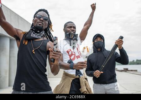 Bewaffnete wütende schwarze Aktivisten protestieren gegen Rassismus, sie sind bereit, mit der Polizei und mit Ungerechtigkeit in den USA zu kämpfen. Schwarze, afroamerikaner, dunkle Haut Stockfoto