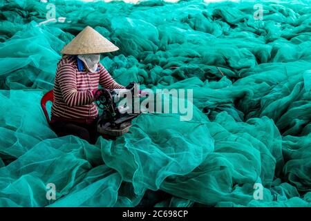 Frau repariert Fischernetze, Vietnam Stockfoto