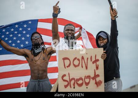 Demonstranten halten Transparente mit dem Motto der schwarzen Bürgerrechtsbewegung "Black Lives Matter", "Don't Shoot", um ihre Solidarität mit Afrikanern zu zeigen Stockfoto