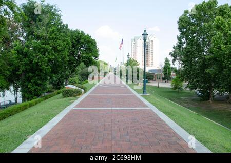 Eine obere Ebene Blick entlang der Riverwalk Fußweg in Augusta, Georgia,. Mit Grasbänken und Bäumen auf beiden Seiten und einem Blick auf den Savannah River Stockfoto