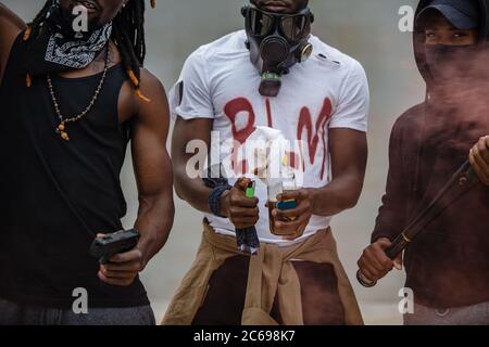 Junge aggressive afrikanamerikanische Männer zündeten während einer Demonstration Flaschen an, nachdem sie von der Polizei einen schwarzhäutigen Mann getötet hatten Stockfoto