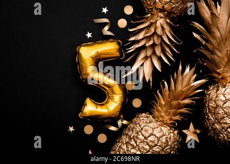 5. Geburtstag Feier Hintergrund mit goldenen Ballons und goldenen Ananas Stockfoto