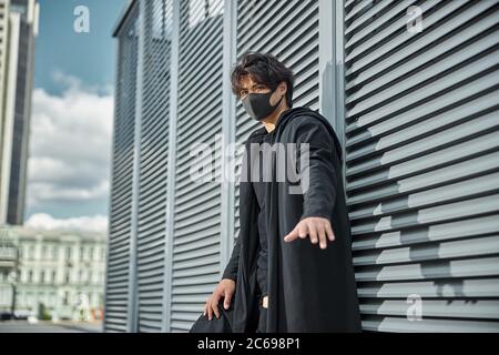 Schöner junger Mann in Schutzmaske auf der Straße stehend Stockfoto