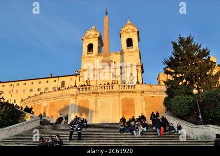 ROM - MÄRZ 10: Touristen sitzen auf der Spanischen Treppe mit der Kirche Santissima Trinita dei Monti an der Spitze in Rom am 10. März 2011. Die Spanische Treppe ist Stockfoto