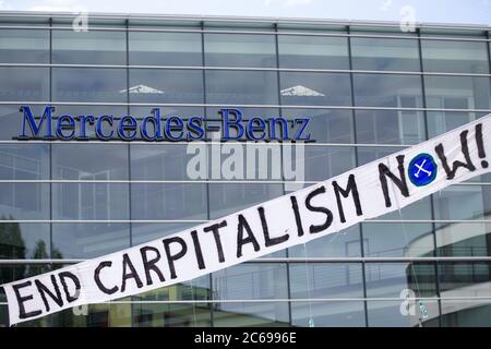 Stuttgart, Deutschland. Juli 2020. Vor dem Mercedes-Benz Global Training Center in Stuttgart-Vaihingen haben Demonstranten Banner mit der Aufschrift 'END CARPITALISM NOW' aufgehängt. Sie fordern eine sozial-ökologische Umstrukturierung des Automobilkonzerns und eine Exportstopp für Militärfahrzeuge. Aufgrund der Corona-Pandemie findet die Hauptversammlung des Automobilherstellers Daimler derzeit später als geplant und nur online statt. Quelle: Tom Weller/dpa/Alamy Live News Stockfoto