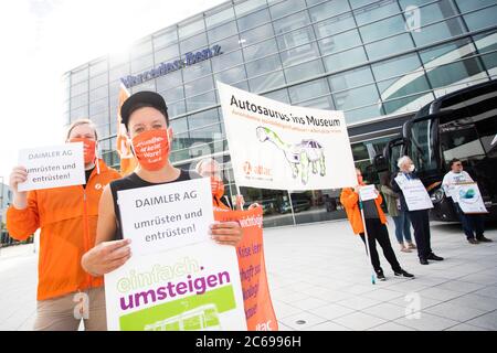 Stuttgart, Deutschland. Juli 2020. Vor dem Mercedes-Benz Global Training Center in Stuttgart-Vaihingen stehen die Demonstranten mit Transparenten wie "Retool und Empörung der Daimler AG" und "Autosaurus ins Museum". Sie fordern eine sozial-ökologische Umstrukturierung des Automobilkonzerns und eine Exportstopp für Militärfahrzeuge. Aufgrund der Corona-Pandemie findet die Hauptversammlung des Automobilherstellers Daimler derzeit später als geplant und nur online statt. Quelle: Tom Weller/dpa/Alamy Live News Stockfoto