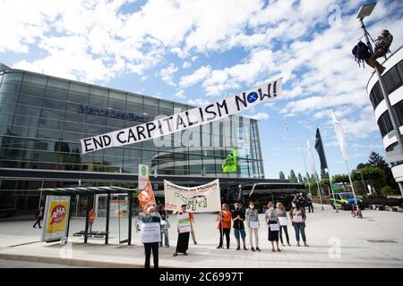 Stuttgart, Deutschland. Juli 2020. Vor dem Mercedes-Benz Global Training Center in Stuttgart-Vaihingen haben Demonstranten ein Banner mit der Aufschrift 'END CARPITALISM NOW' aufgehängt. Sie fordern eine sozial-ökologische Umstrukturierung des Automobilkonzerns und eine Exportstopp für Militärfahrzeuge. Aufgrund der Corona-Pandemie findet die Hauptversammlung des Automobilherstellers Daimler derzeit später als geplant und nur online statt. Quelle: Tom Weller/dpa/Alamy Live News Stockfoto