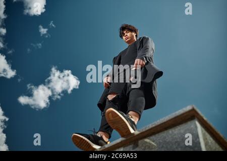 Schöner junger Mann, der unter einem schönen blauen Himmel steht Stockfoto