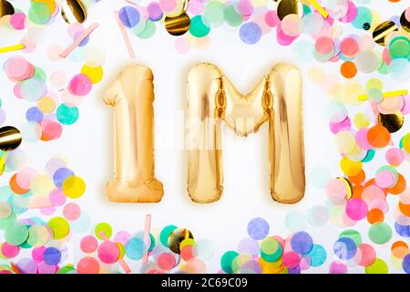 Eine Million Anhänger Konzept aus goldenen aufblasbaren Ballons im Rahmen von bunten Konfetti auf weißem Hintergrund. Stockfoto