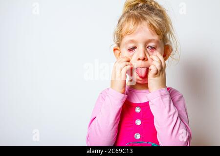 Portrait von süßen kleinen Mädchen, wie sie ihre Zunge aus, kriechende Zunge steckt. Stockfoto