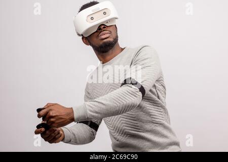 Ethnische dunkelhäutige Bärtigen männliches Modell in Virtual Reality headset Tennis spielen in der erweiterten Realität. Zukunft. Zukunft Technik Konzept. Isoliert auf Stockfoto