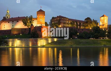 Wawel Schloss beleuchtet in der Nacht mit den Reflexionen in der Weichsel in der Nacht. Stockfoto