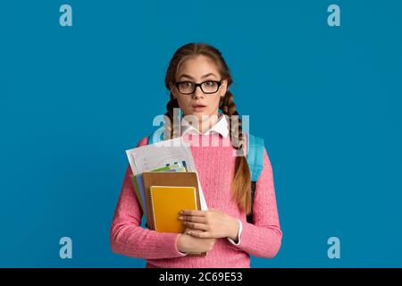 Schule, Hochschule und Universität Konzept. Überrascht, Angst Mädchen hält Notebooks und Grafiken Stockfoto